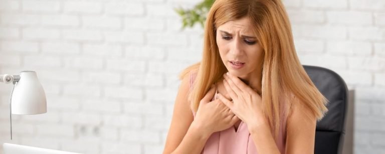 Vrouw met handen bij haar keel door hyperventilatie