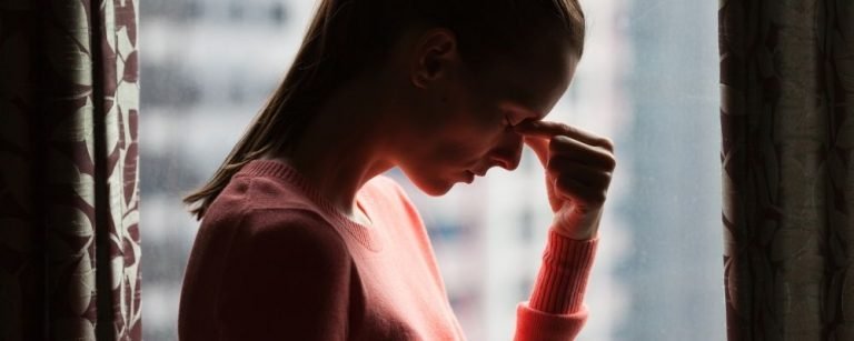 Vrouw met chronische stress die haar voorhoofdsbeen vasthoudt