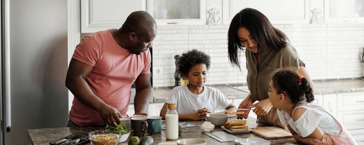 Gezinsopstelling met vader, moeder en twee kinderen die samen koken