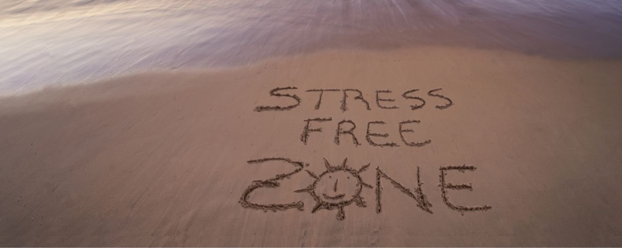 Stress Free Zone geschreven in het zand van een strand